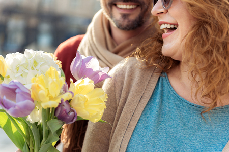 Happy lady getting bouquet from her husbandの写真素材