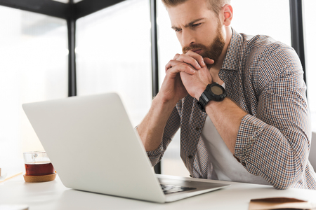 Frowning office worker hardly thinkingの写真素材