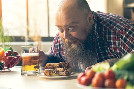 Shocked thick guy looking at chicken legsの写真素材