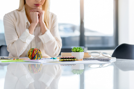 Wonderland. Reflection of different colored things in worktable. Elegant woman sitting at desk in background. Copy space in the right sideの写真素材
