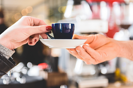 Woman arm getting mug of beverageの写真素材