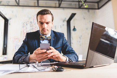 Serene male watching at cellphone in roomの写真素材