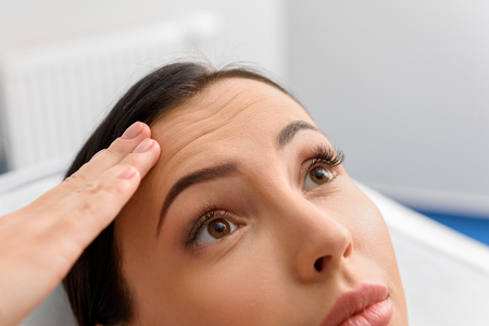 Surprised female showing wrinkle on faceの写真素材