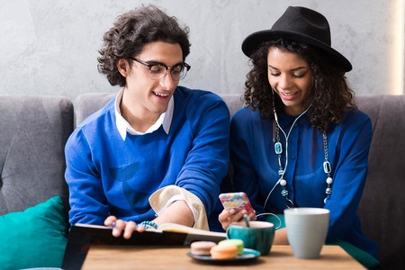 Joyful young man and woman in cafeの写真素材
