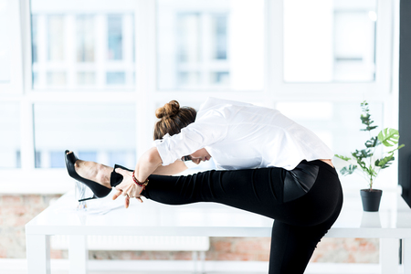 Calm woman making gymnastics at jobの写真素材