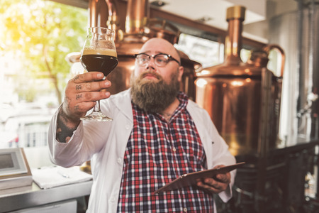 Obese male in glasses making lager