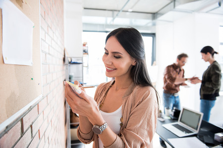 Merry smiling office worker making notesの写真素材