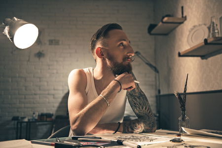 Pensive bearded male painting picturesの写真素材