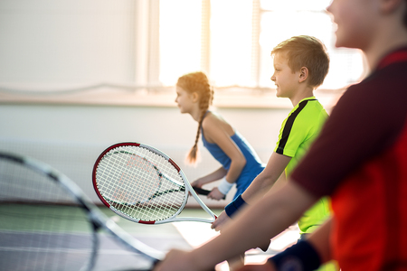 Happy pupils enjoying tennis gameの写真素材