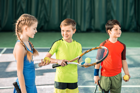 Happy children playing tennis on playgroundの写真素材