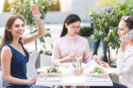 Happy lady sitting at table in cafeの写真素材