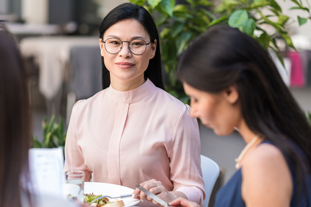 Happy woman tasting food at deskの写真素材