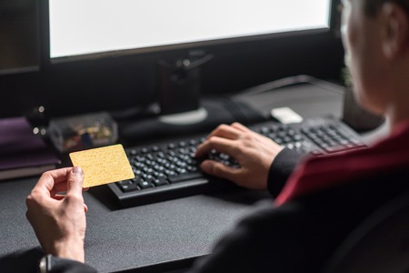 Man hand writing information on computer