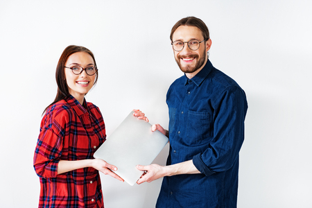 Cheerful smart couple presenting modern technologyの写真素材