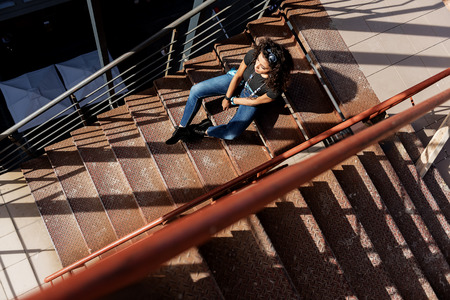 Thoughtful mulatto girl relaxing on staircase