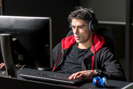 Astonished man working by computer in roomの写真素材