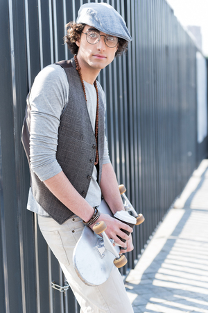 Stylish hipster boy is standing outdoorsの写真素材