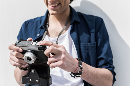 Happy trendy guy is reviewing picturesの写真素材