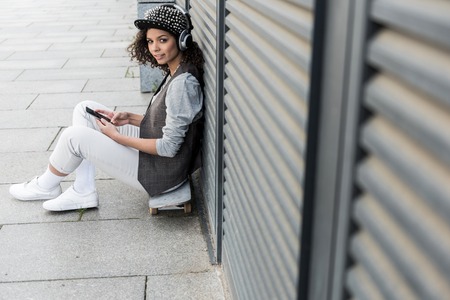 Stylish young girl is resting outdoors with pleasureの写真素材