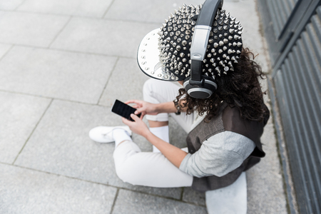 Fashionable teenage girl is listening to musicの写真素材