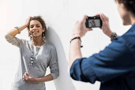 Cheerful couple is standing with camera in open airの写真素材