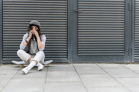 Stylish pleasant teenager is resting on street