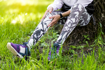 Senior slim lady resting in summer park after runningの写真素材