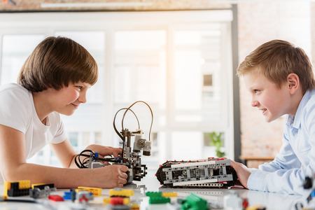 Cheerful male children playing with roboticsの写真素材