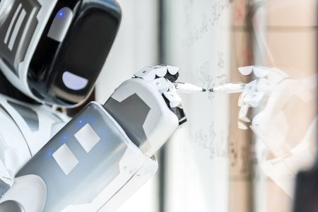 Smart robot is standing against transparent boardの写真素材