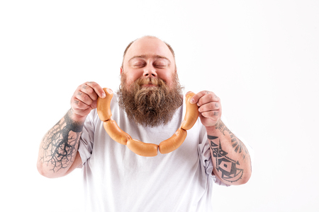 Joyful thick guy enjoying smell of meatの写真素材