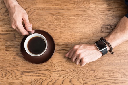 Youthful guy having little break with hot beverageの写真素材