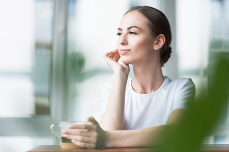 Happy attractive girl having morning rest indoorの写真素材