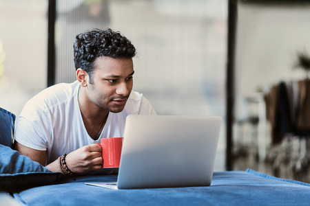 Relaxed male freelancer enjoying hot beverageの写真素材