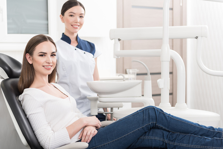 Smiling patient and cheerful odontologist locating in apartmentの写真素材