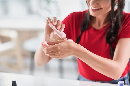 Confident girl preparing make-up base for her faceの写真素材