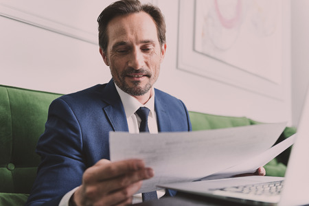Smart businessman working with papers and laptop