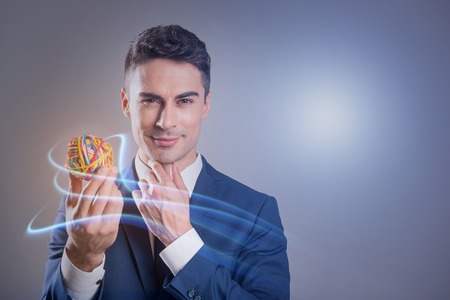 Cheerful elegant man is demonstrating rubber sphere