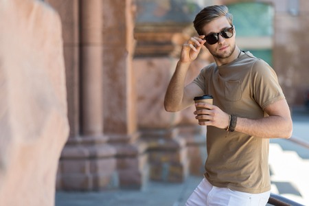 Solemn youthful bearded guy resting outdoorの写真素材