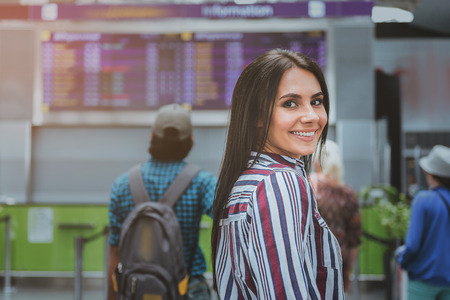Hilarious smiling woman in airportの写真素材