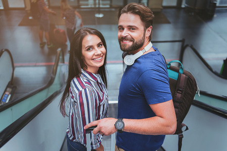 Joyful lovers are standing together on escalatorの写真素材