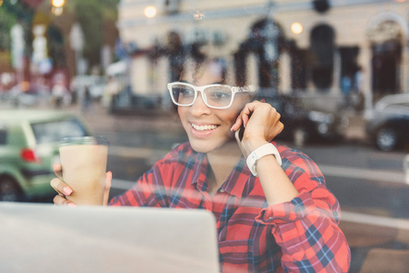 Positive stylish girl is calling by smartphoneの写真素材
