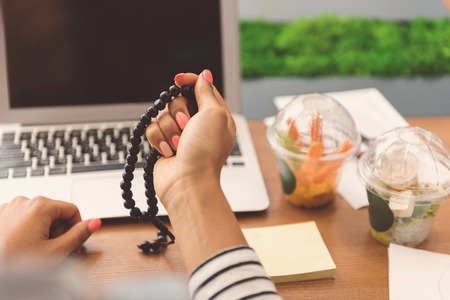Young woman is enumerating her rosaryの写真素材
