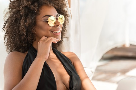 Cheery youthful mulatto lady taking pleasure resting outdoorの写真素材