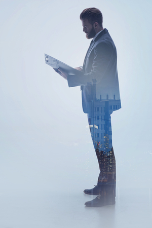 Serious male manager working with city background projectionの写真素材