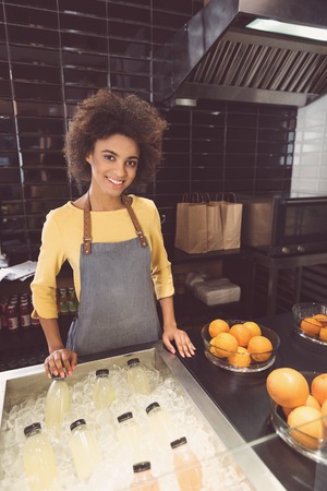 Cheerful young woman is laboring in organic food storeの写真素材