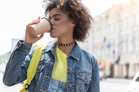 Attractive stylish girl is enjoying coffee outdoorsの写真素材