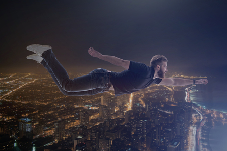 Double exposure with young man flying under city backgroundの写真素材
