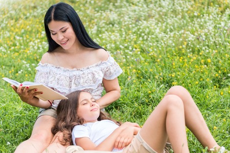 Happy mother telling interesting story to her dreamy childの写真素材