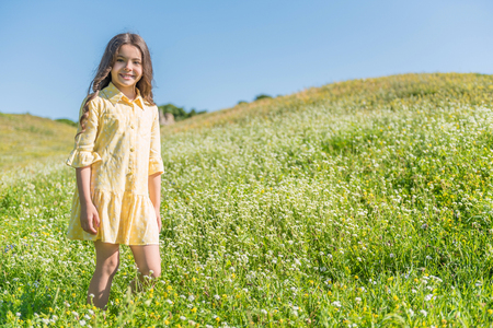 Joyful female kid having fun on summer fieldの写真素材