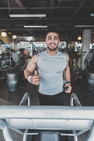 Outgoing man doing cardio in modern gymの写真素材
